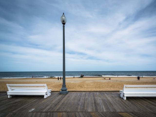 White benches on the boardwalk overlooking Rehoboth Beach in Delaware.