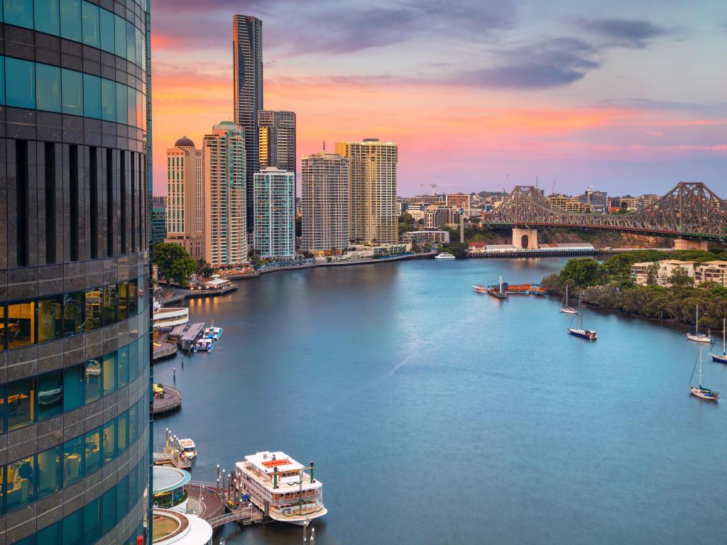 Cityscape image of Brisbane skyline during sunset, taken from a high vantage point overlooking the river and tall buildings