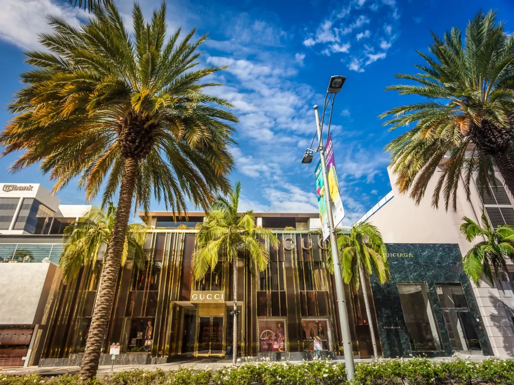 Exterior of a Gucci Store in LA's fashion district with palm trees and blue sky