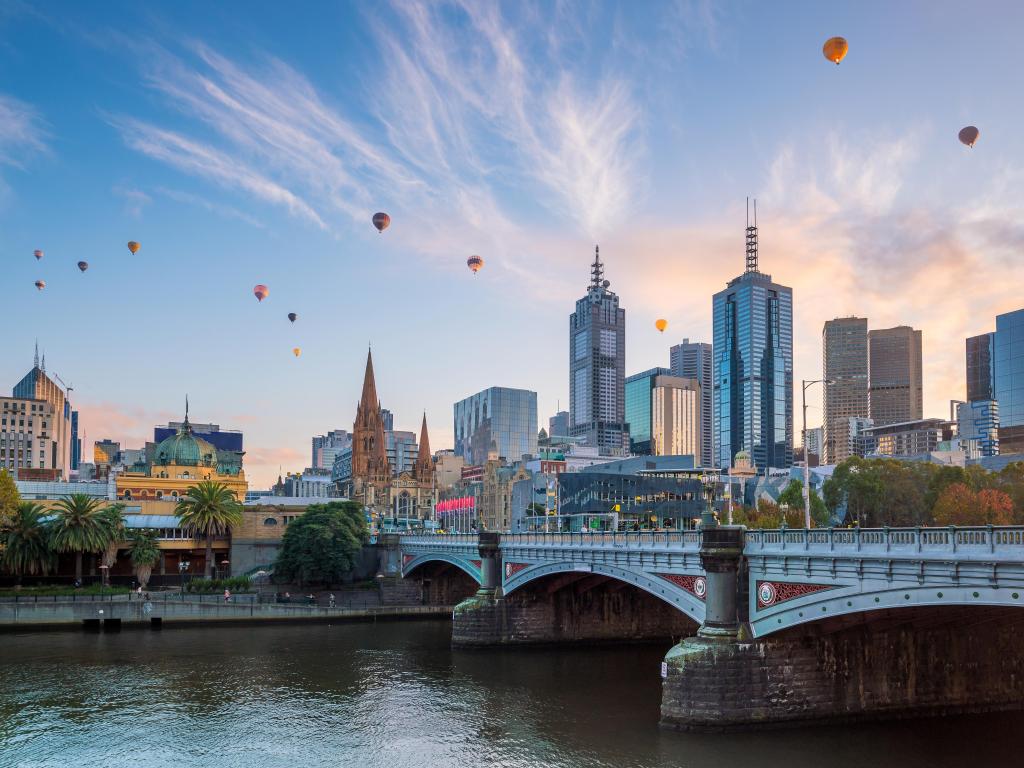Melbourne, Australia with the city skyline at twilight and balloons in the sky.
