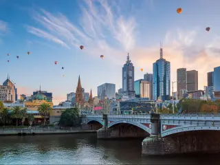 Melbourne, Australia with the city skyline at twilight and balloons in the sky.