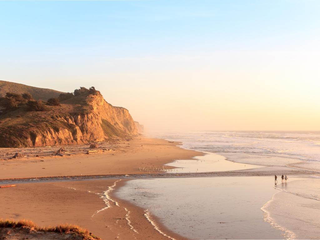 Half Moon Bay, California, USA with a view of San Gregorio State Beach and Pacific Ocean at sunset with cliffs in the distance. 