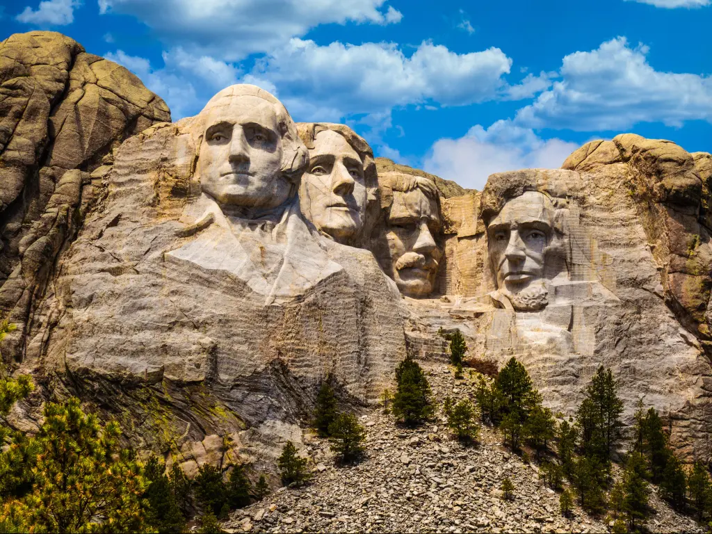 Mount Rushmore, South Dakota, USA with the sculptures of Four United States Presidents at sunrise against a blue sky.