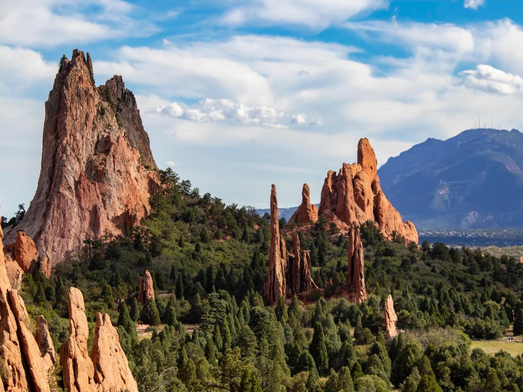 The towering red rock formations of the Garden of the Gods of Colorado Springs with Cheyenne Mountain in the background