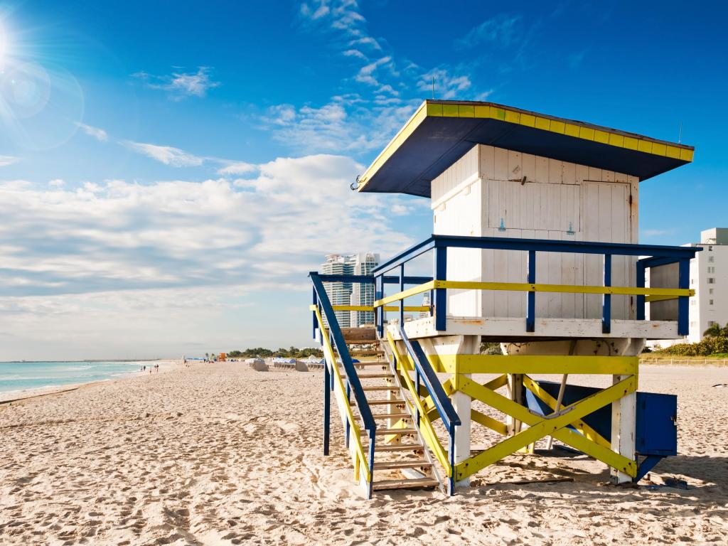 Lifeguard tower on sandy beach with clear blue sky and blue sea