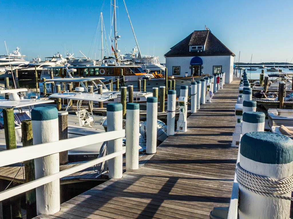 Many yachts are docked at Sag Harbor, Long Island in a bright day.
