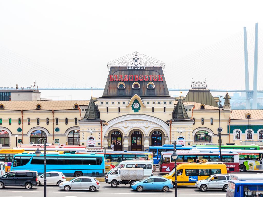 Square in front of Vladivostok Railroad Station packed with vehicles with Railroad Station in the background