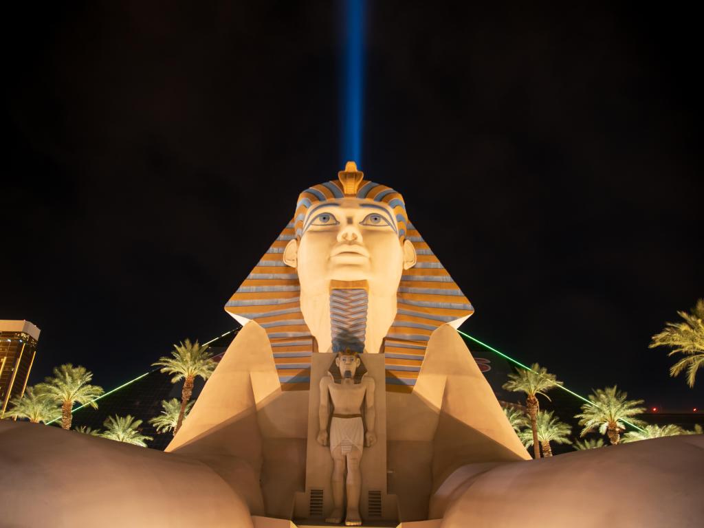 The famous Sphinx replica at the hotel with a light beam going straight up in the sky behind it at night