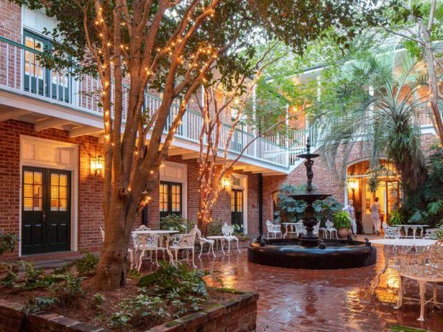 Outdoor courtyard with furniture, cobblestones, fountain and fairy lights in the trees, at Hotel Provincial, New Orleans