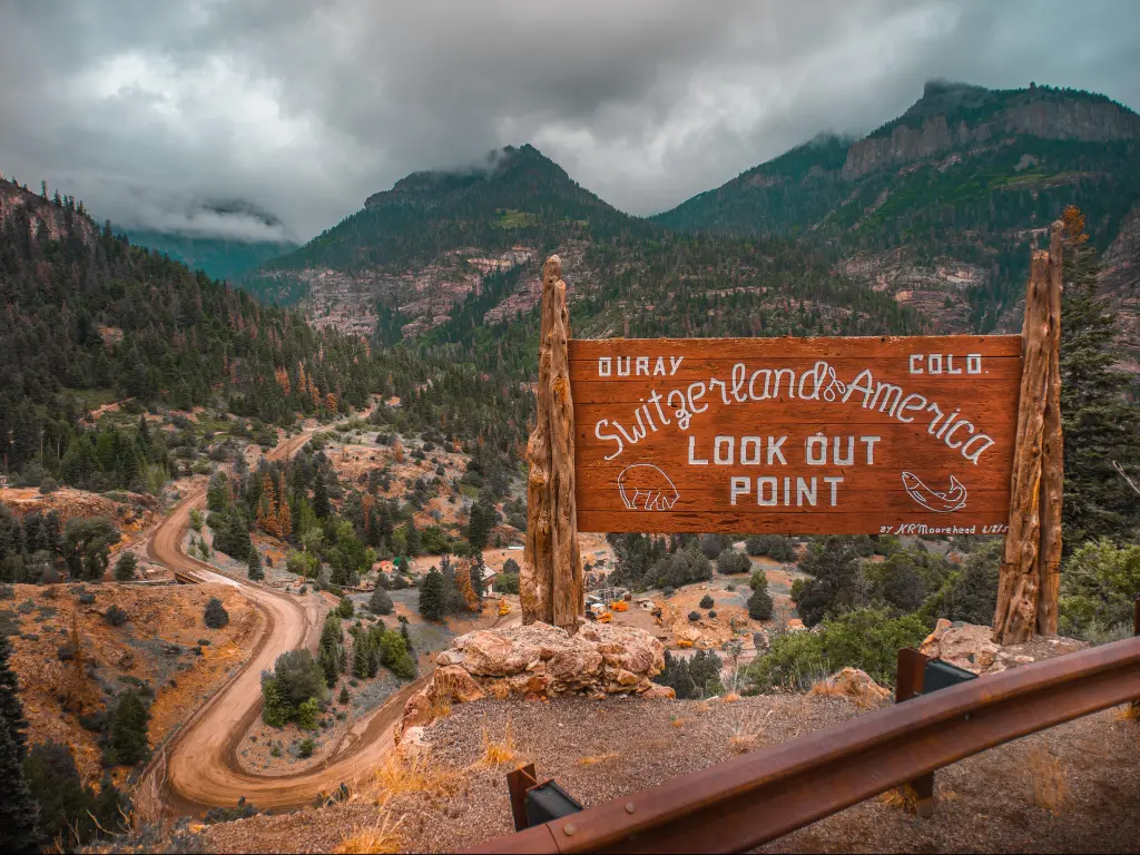 Wooden sign saying "Ouray, The Switzerland of America" overlooking the San Juan National Forest in Colorado
