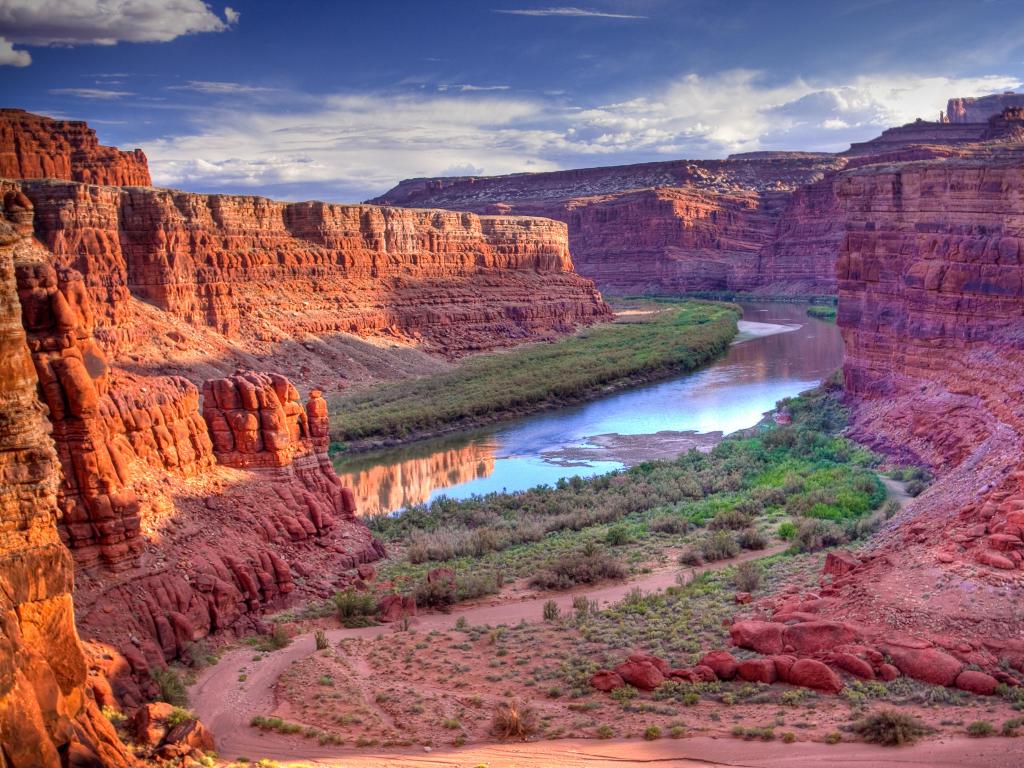 Canyonlands National Park, Utah with The Colorado River running through the valley and tall cliffs either side on a cloudy day.