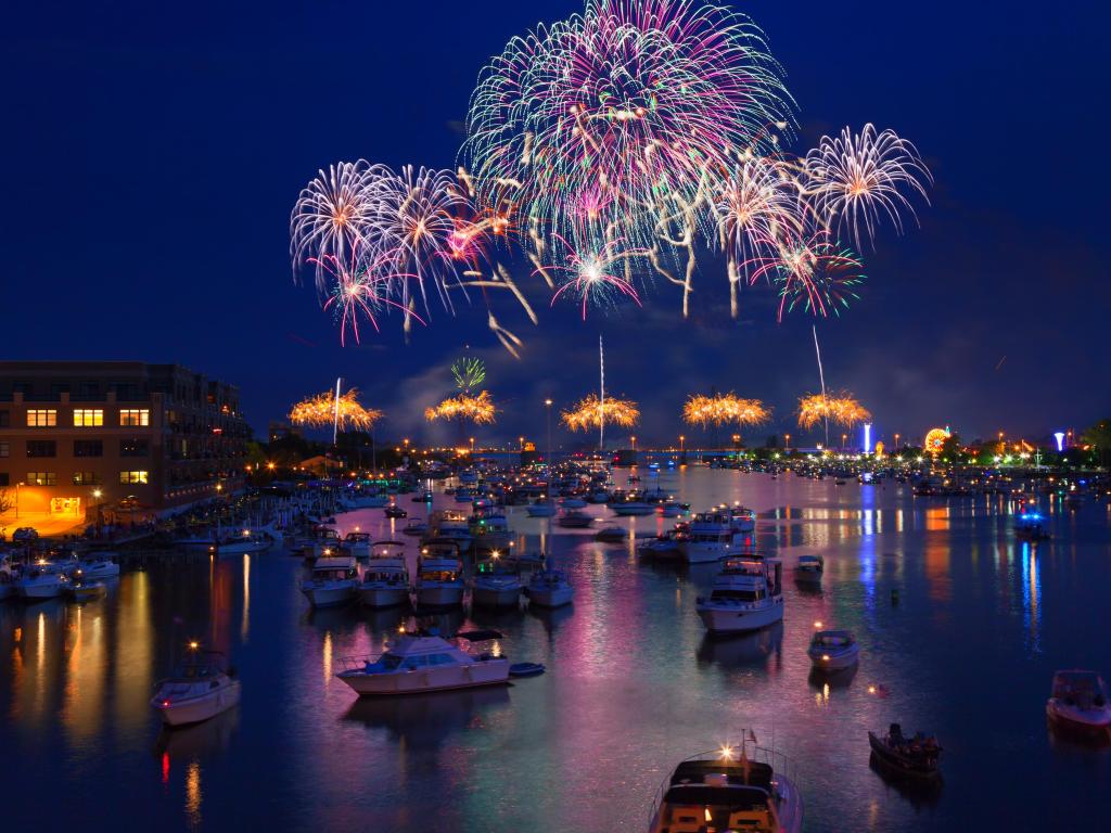 Fireworks explode in a glorious display over the Saginaw River at Bay City Michigan's annual fireworks show. Crowds gather in boats on the river to watch the display and celebrate Independence Day.