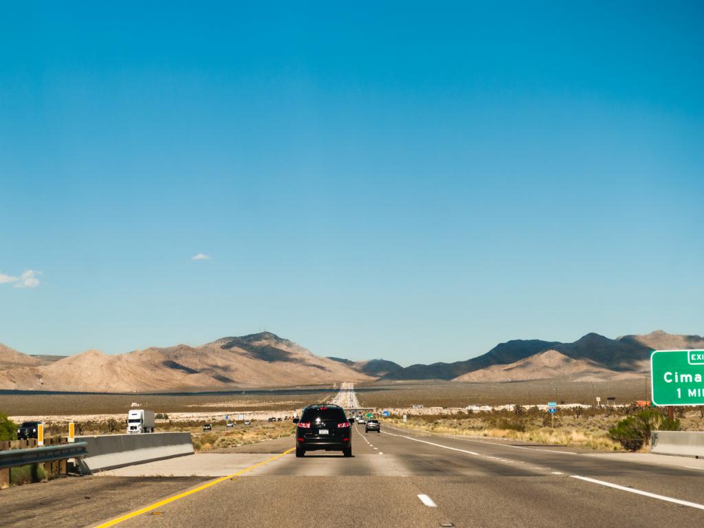 Interstate 15 freeway in Mojave on a sunny morning with a scenic view of the mountains.