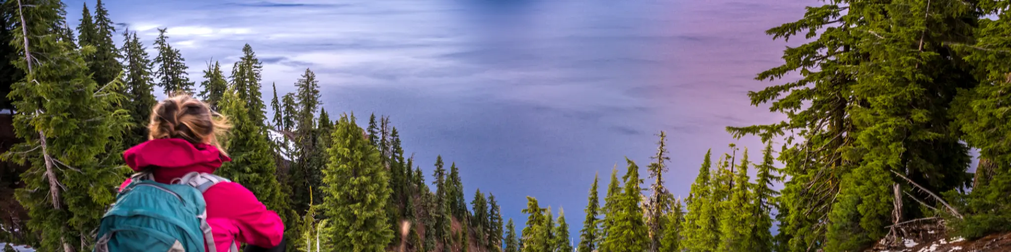 Hiker admires the sunset mountain views in Crater Lake, Oregon