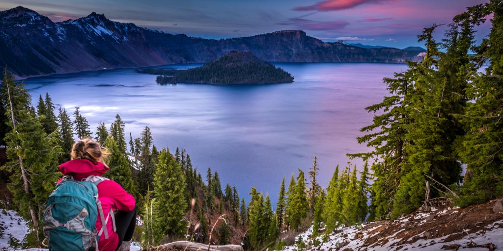 Hiker admires the sunset mountain views in Crater Lake, Oregon