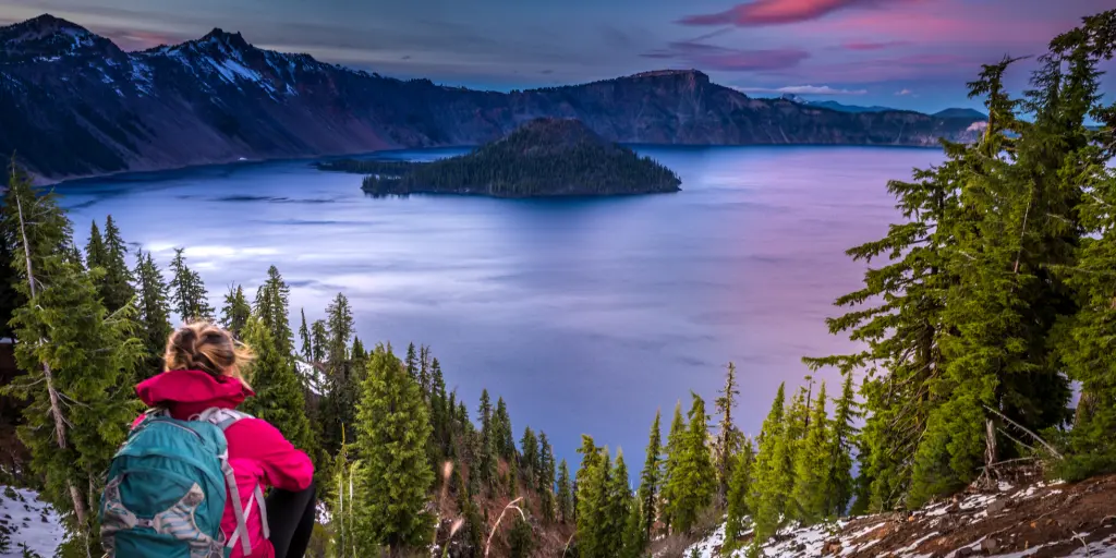 Hiker admires the sunset mountain views in Crater Lake, Oregon