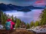Hiker admires the sunset mountain views in Crater Lake, Oregon