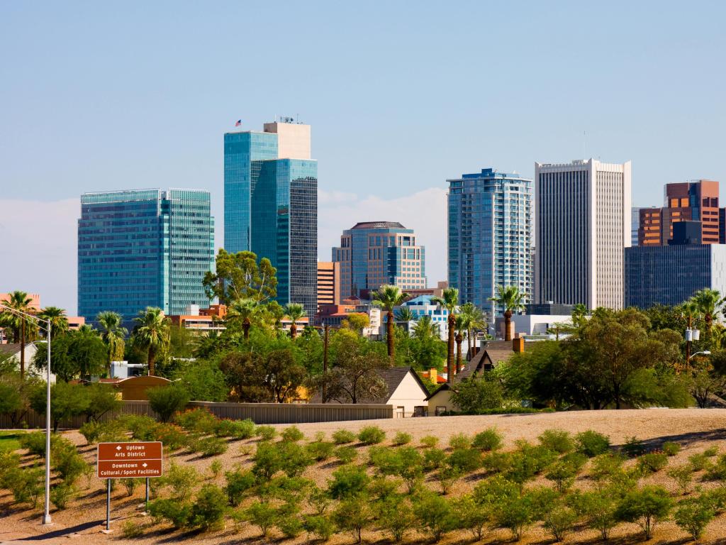 Phoenix, Arizona, USA with the city in the background, trees and desert in the foreground on a sunny day, 