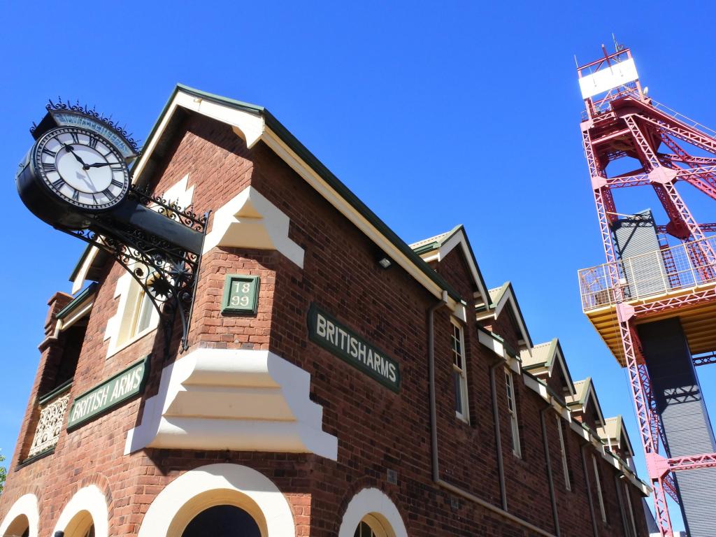 Old fashioned brick building with mining tower next to it