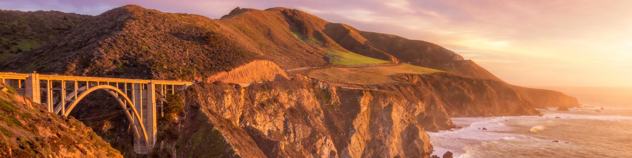 Bixby Creek Bridge in Monterey County, California taken at sunset with dramatic cliffs and sea.