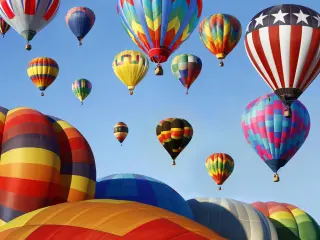 Hot air balloons in the sky with no cloud in sight