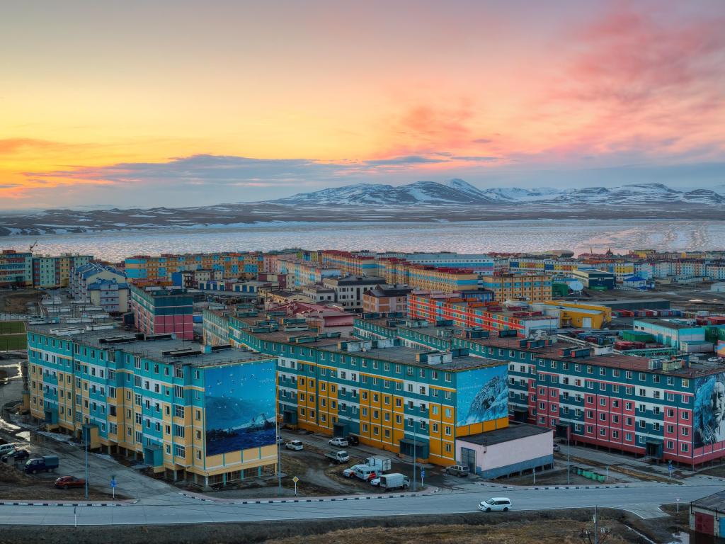 Anadyr, Chukotka, Russia at the Northern city in the Arctic in the Russian Far East. Top view of multicolored residential buildings. Anadyr estuary and mountains in the distance. Summer night