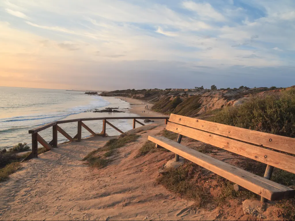 Crystal Cove Beach, California, USA with a bench along an outlook with a view of Crystal Cove Beach, Newport Beach and Laguna Beach line in Southern California