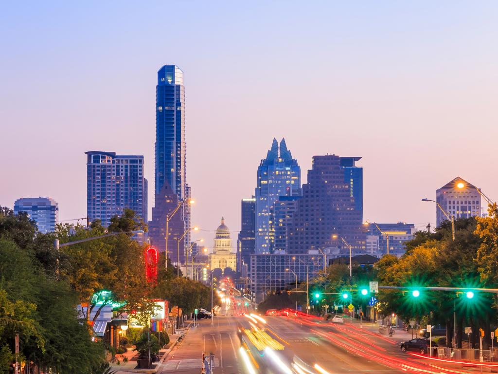 A view of the Austin, Texas skyline at night with the Texas State Capitol building in the background.