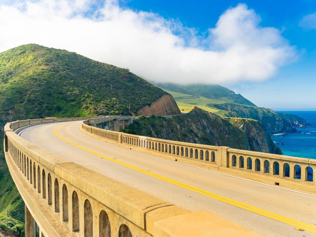 Bixby Creek Bridge on Highway (Highway 1) at the US West Coast traveling south to Los Angeles, with mountains and sea in the background