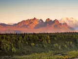 Denali National Park with mountains glowing in the sunrise light and the forest and river in the foreground