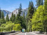 Tourist van on the tourist road in Yosemite National Park, California, USA. Panorama of the Yosemite valley and Yosemite Falls in summer