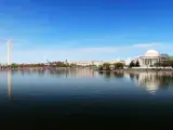 Washington DC, USA with a skyline panorama with Washington monument and Thomas Jefferson memorial on a clear sunny day, water in the foreground.