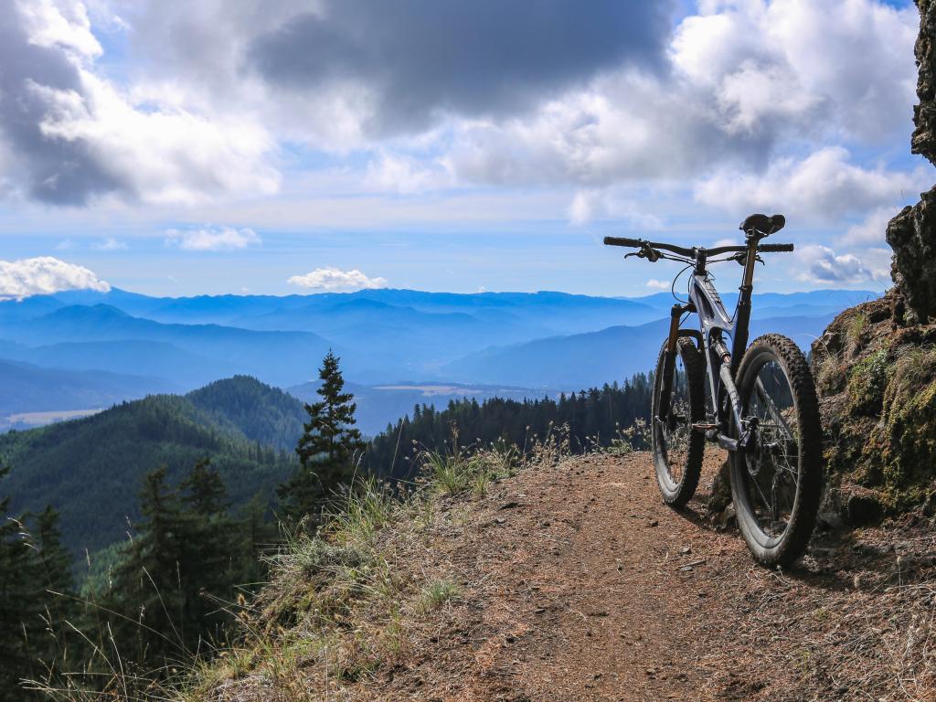 Oakridge, Oregon, USA with a mountain bike on the Alpine Trail overlooking a stunning view of mountains and valleys in the distance.