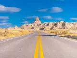 Road leading to Badlands National Park, sunny day with blue skies