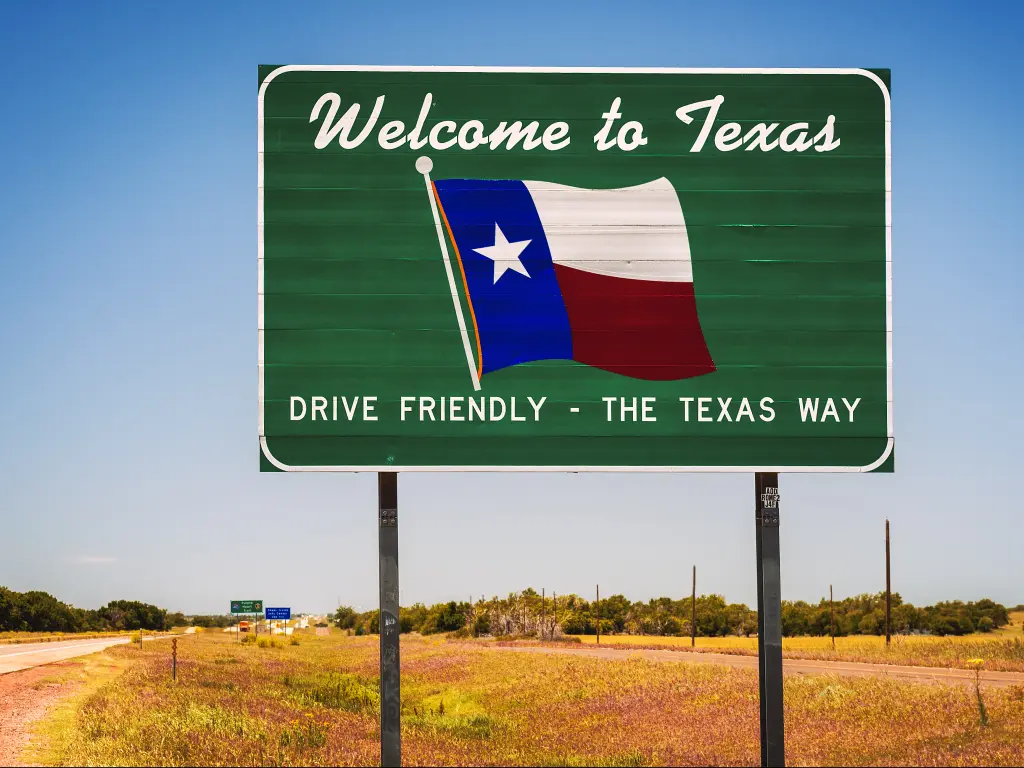 Welcome to Texas road sign at the state border saying Drive Friendly - The Texas Way