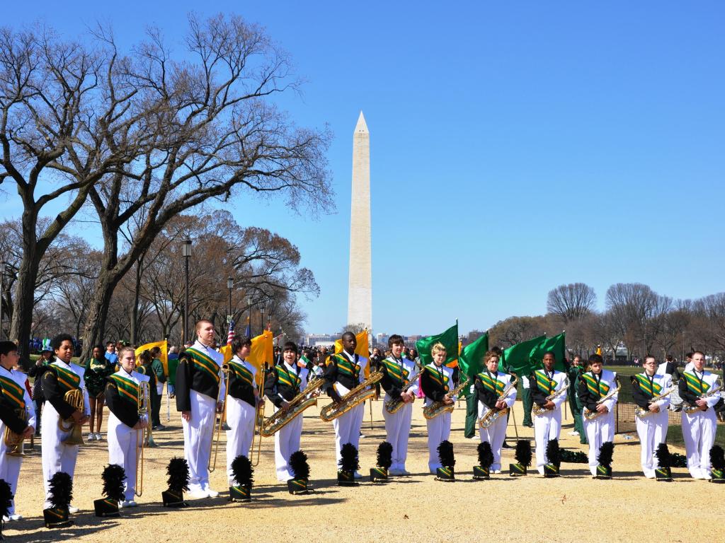 Marching band dressed in green uniforms getting ready to perform at St Patrick's Parade