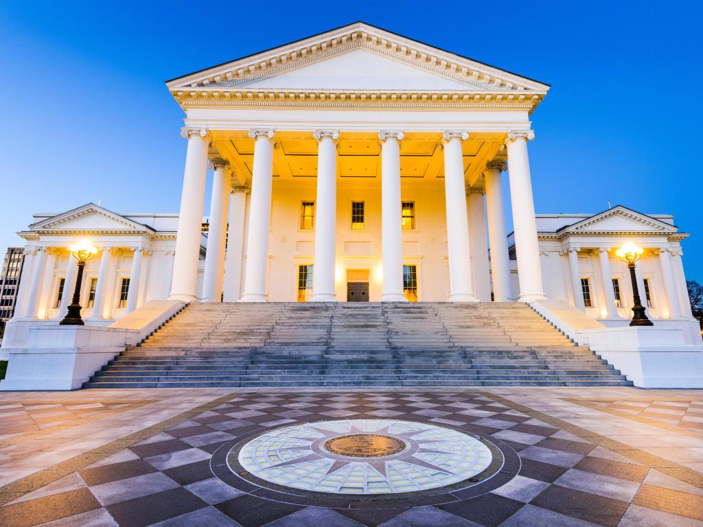 White column-fronted official building with black and white marble foreground