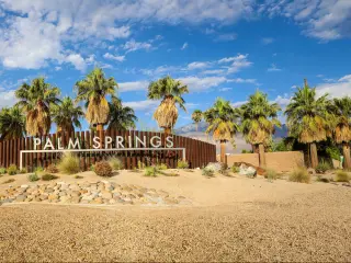 Palm Springs sign on entering the city, with blue sky above, California