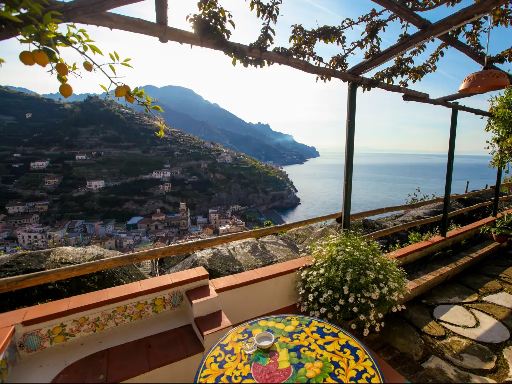 Scene from balcony overlooking city and ocean in Amalfi Coast