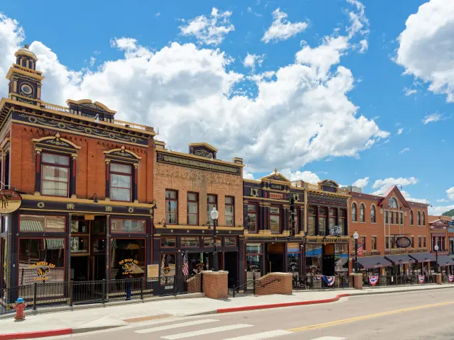 Row of old-fashioned Wild West buildings that now house casinos on a partially cloudy day