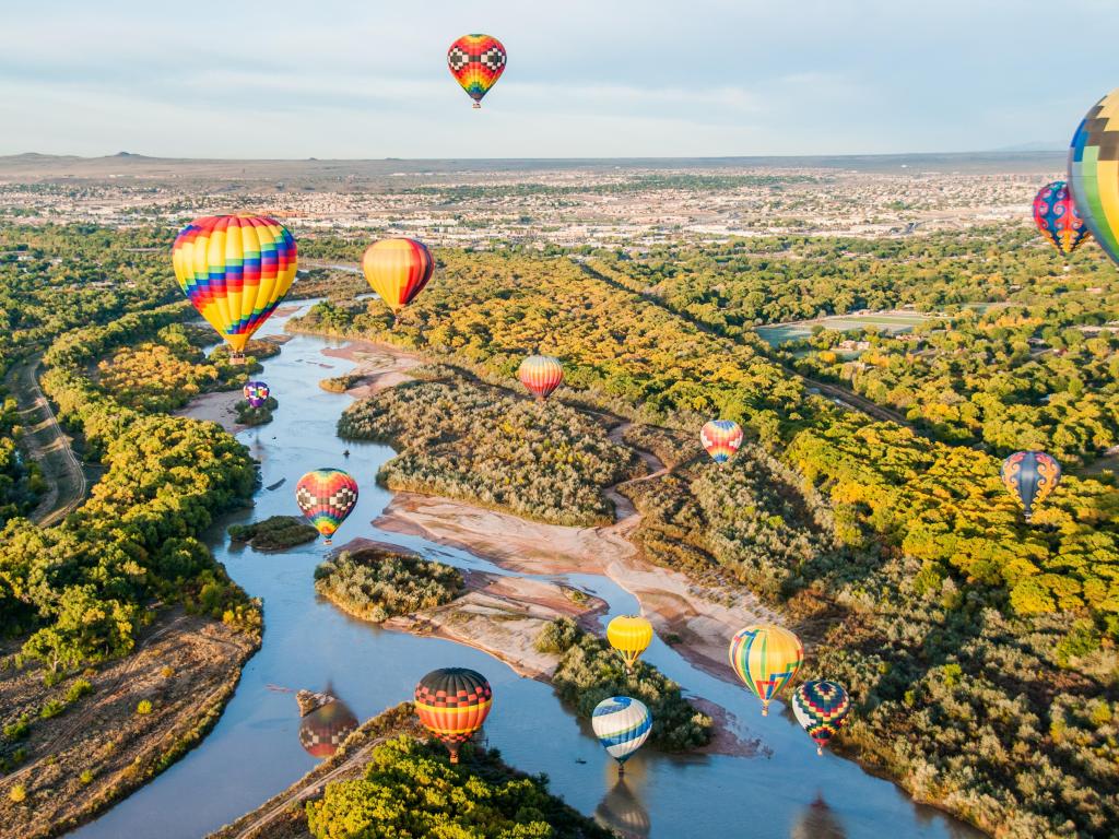 Balloons over the Rio Grande River in Albuquerque on a sunny day.