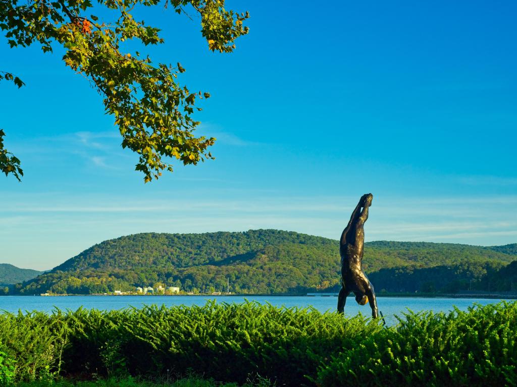 From a certain viewpoint, a bronze statue of a diver in the picturesque Riverfront Green Park of this city seems to be poised for a plunge into the Hudson River. Photo taken on a sunny day