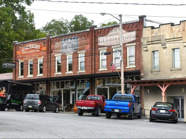 View of a historic street in Lynchburg, TN. Wooden storefronts of Drug Store, Lynchburg Hardware and the General Store